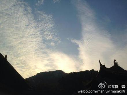 南海普陀山观音大士在长空手持杨枝白玉瓶，现出白衣大身宝相加持信众