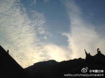 南海普陀山观音大士在长空手持杨枝白玉瓶，现出白衣大身宝相加持信众